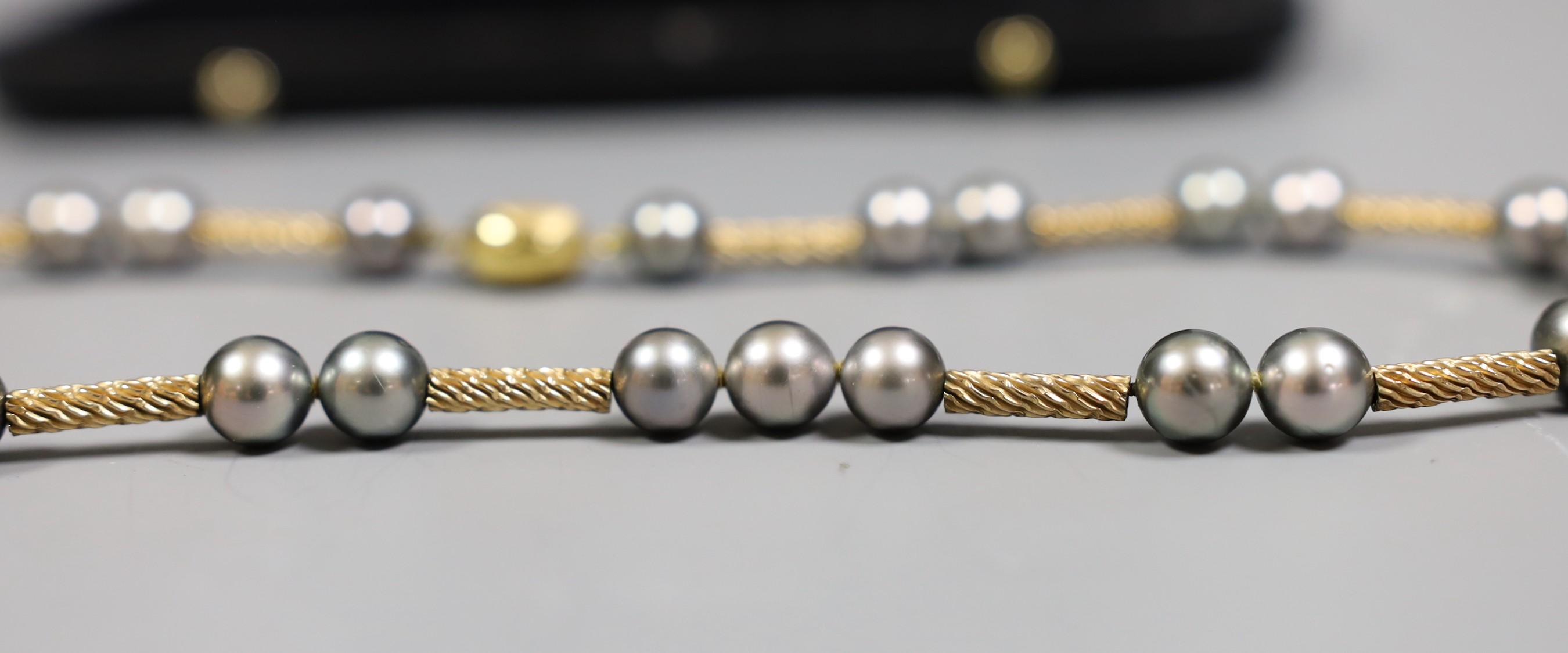 A cased modern 750 yellow metal and Tahitian? pearl set necklace, with diamond chip set clasp, 39cm, gross weight 31.1 grams.
